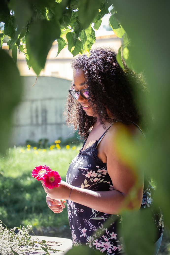 Femme qui tient des fleurs